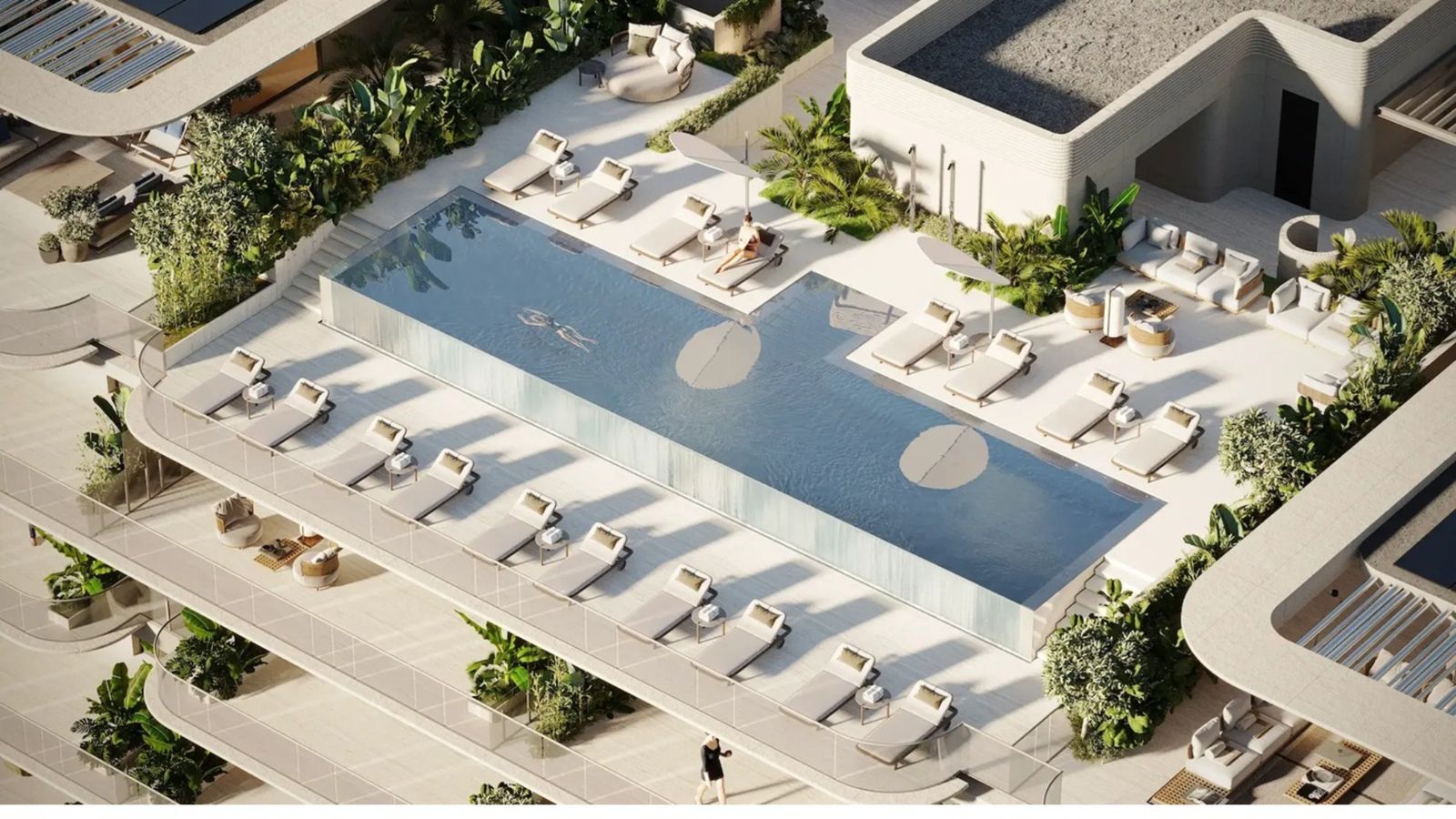 Luchtfoto van zwembad bij Tyrian Residences met ligstoelen en weelderig groen.